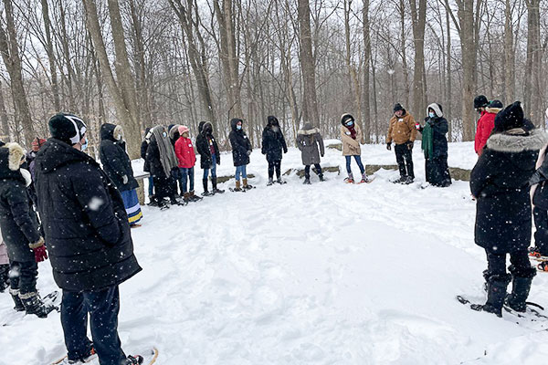 group of students standing outside in the snow in a half circle