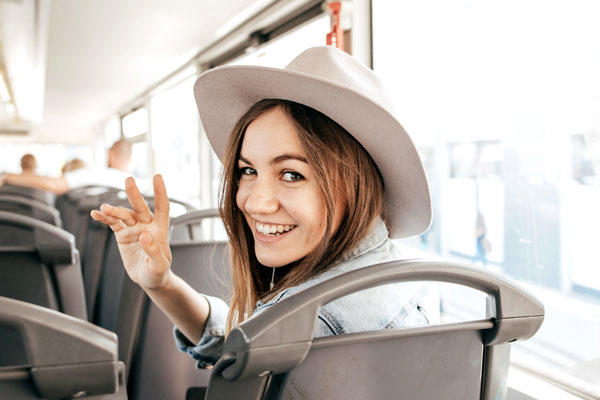 Person on bus wearing hat smiling