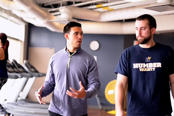 two people walking in the gym and talking