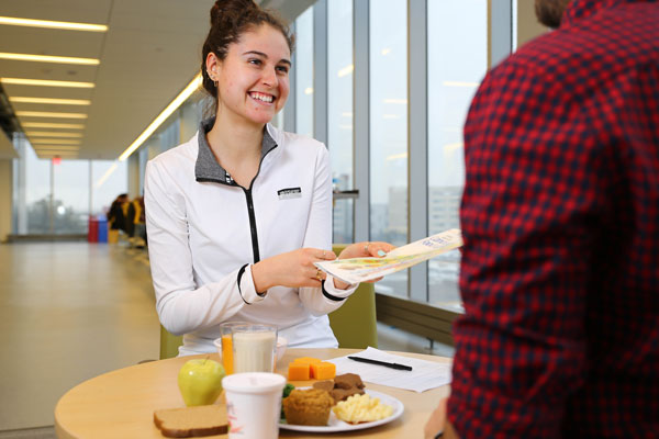 Nutrition student at table with meal and food guide