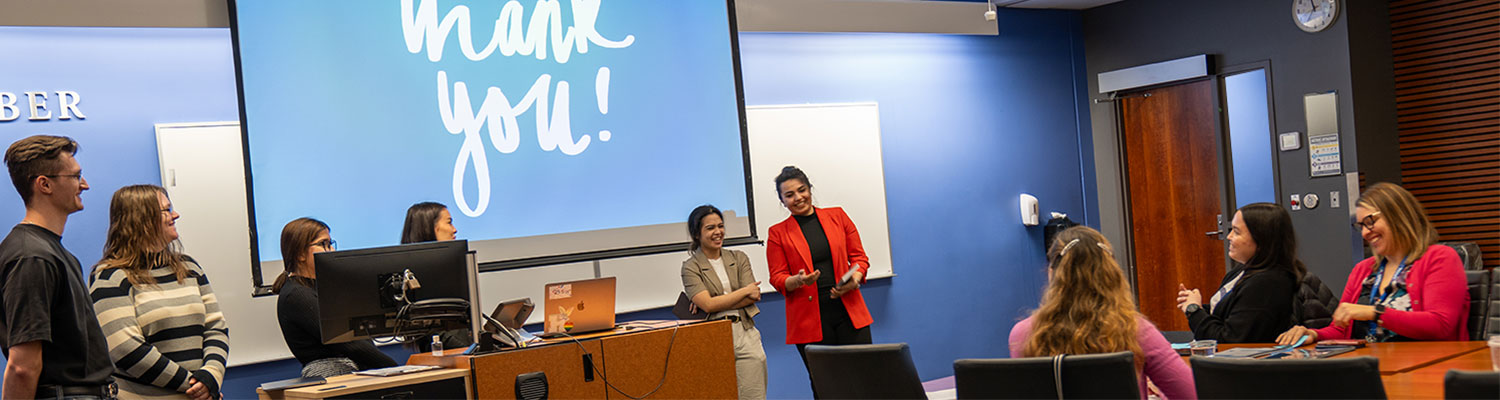 people sitting at a table listening to a presentation