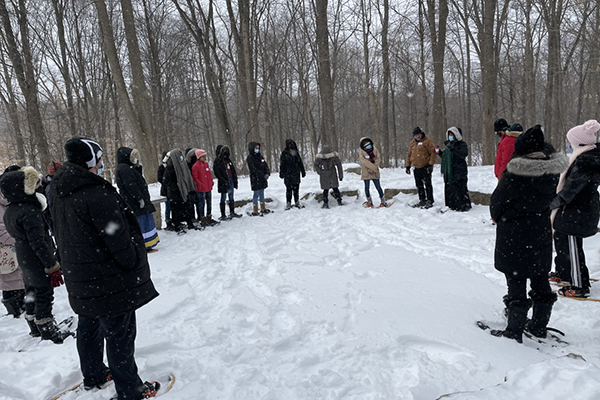 students standing outside in the snow at the rock circle