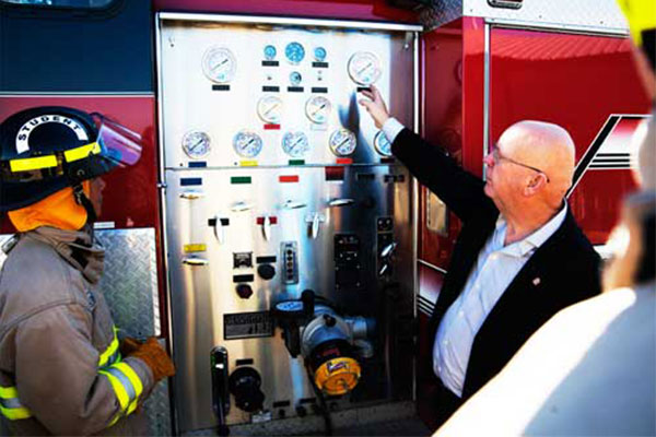 Faculty member explaining parts on a fire engine