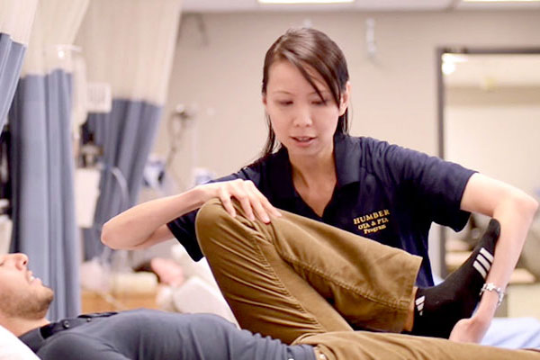 Person bending leg of patient on bed