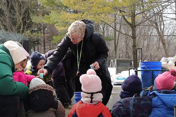 woman handing cups out to kids