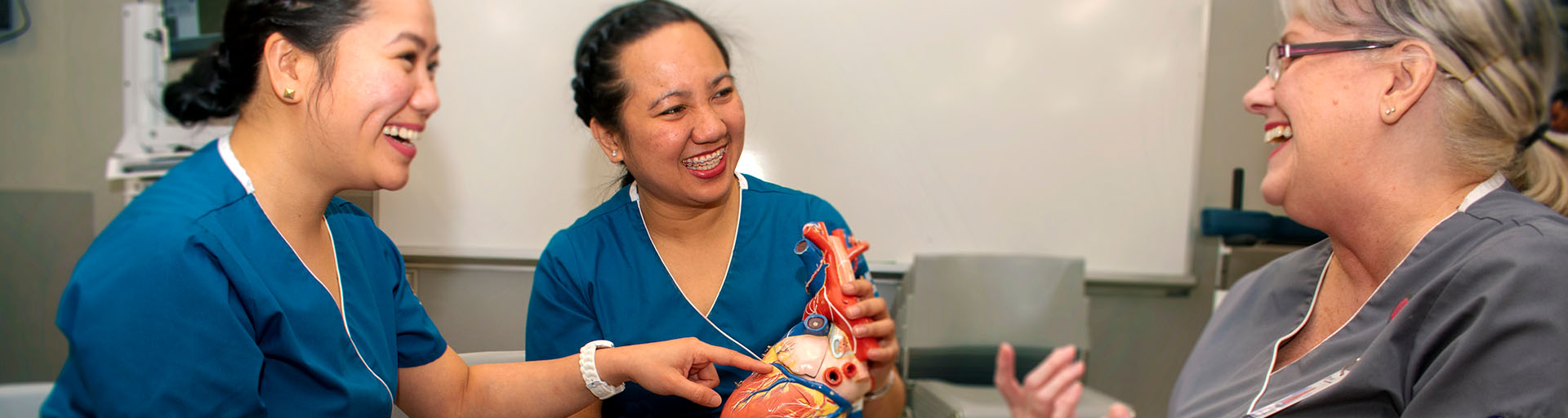 female nursing students holding a demonstrative heart