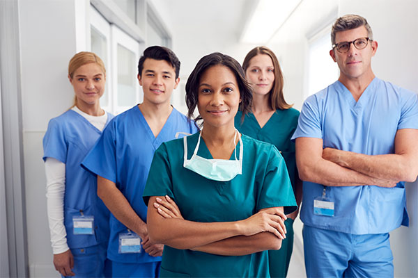 a group of medical professionals in scrubs with their arms crossed