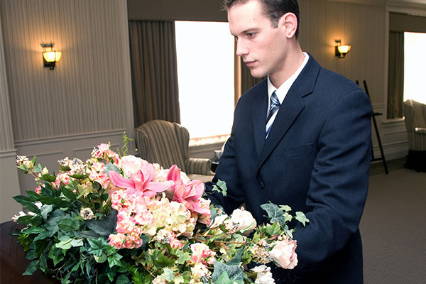 Person in funeral parlor arranging flowers