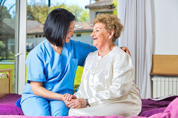 nurse sitting with and elderly person