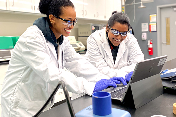 women looking at laptop and smiling