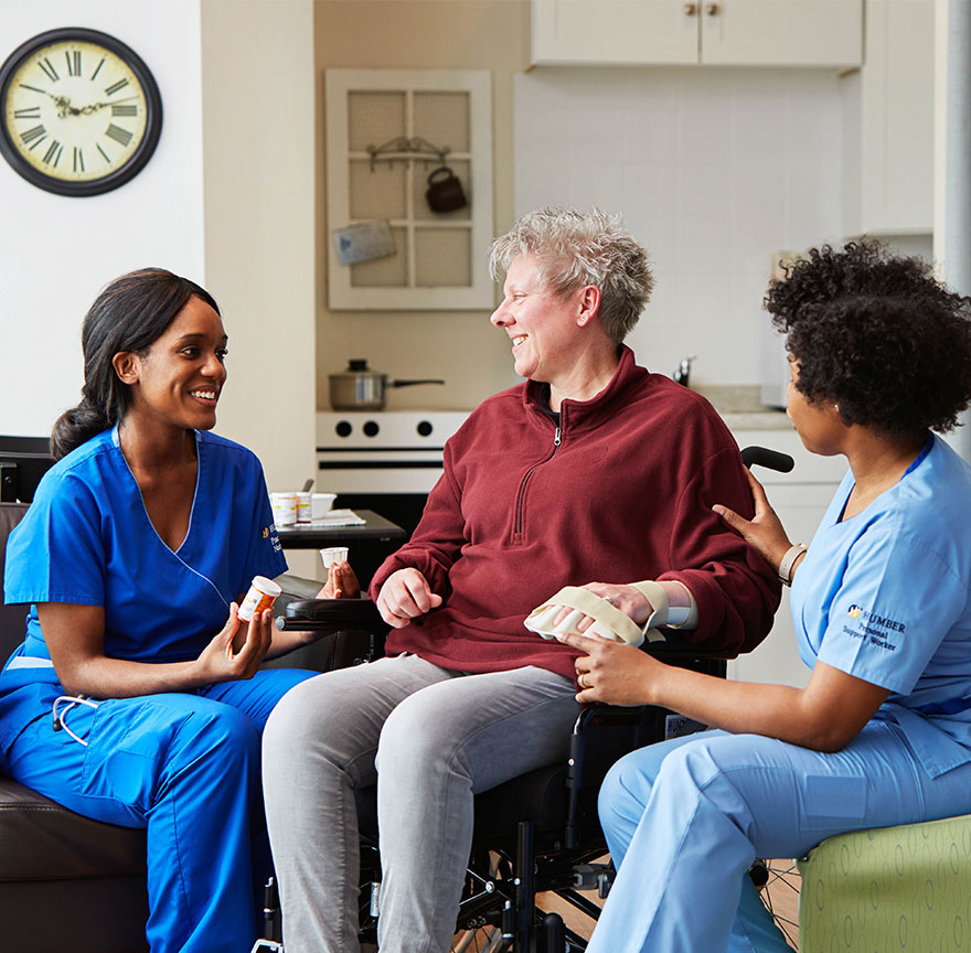 two nursing students helping an elderly person