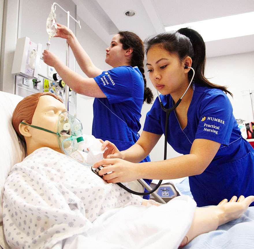 two nursing students performing CPR on a practice mannequin