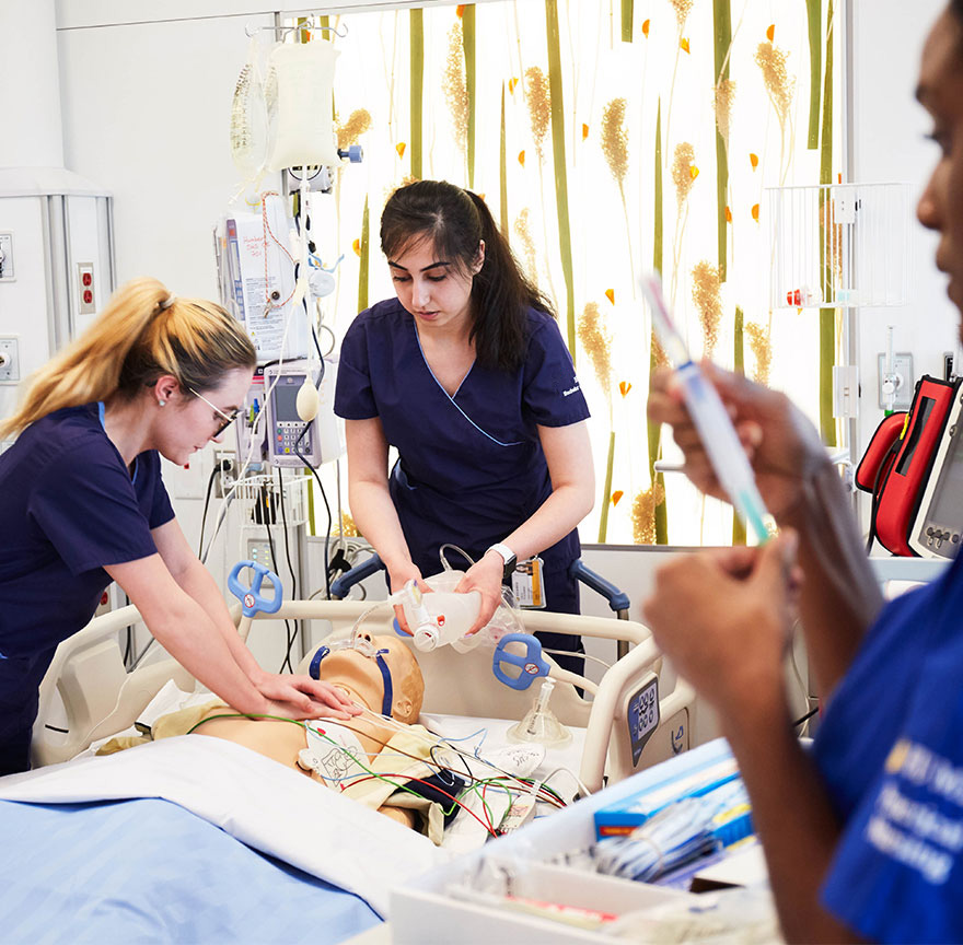 two nursing students performing CPR on a practice mannequin