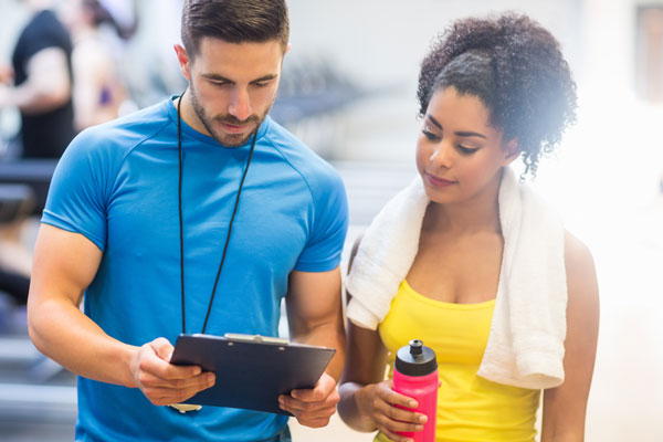 Person looking at clipboard with personal trainer