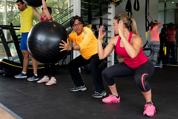 Trainer guiding person exercising